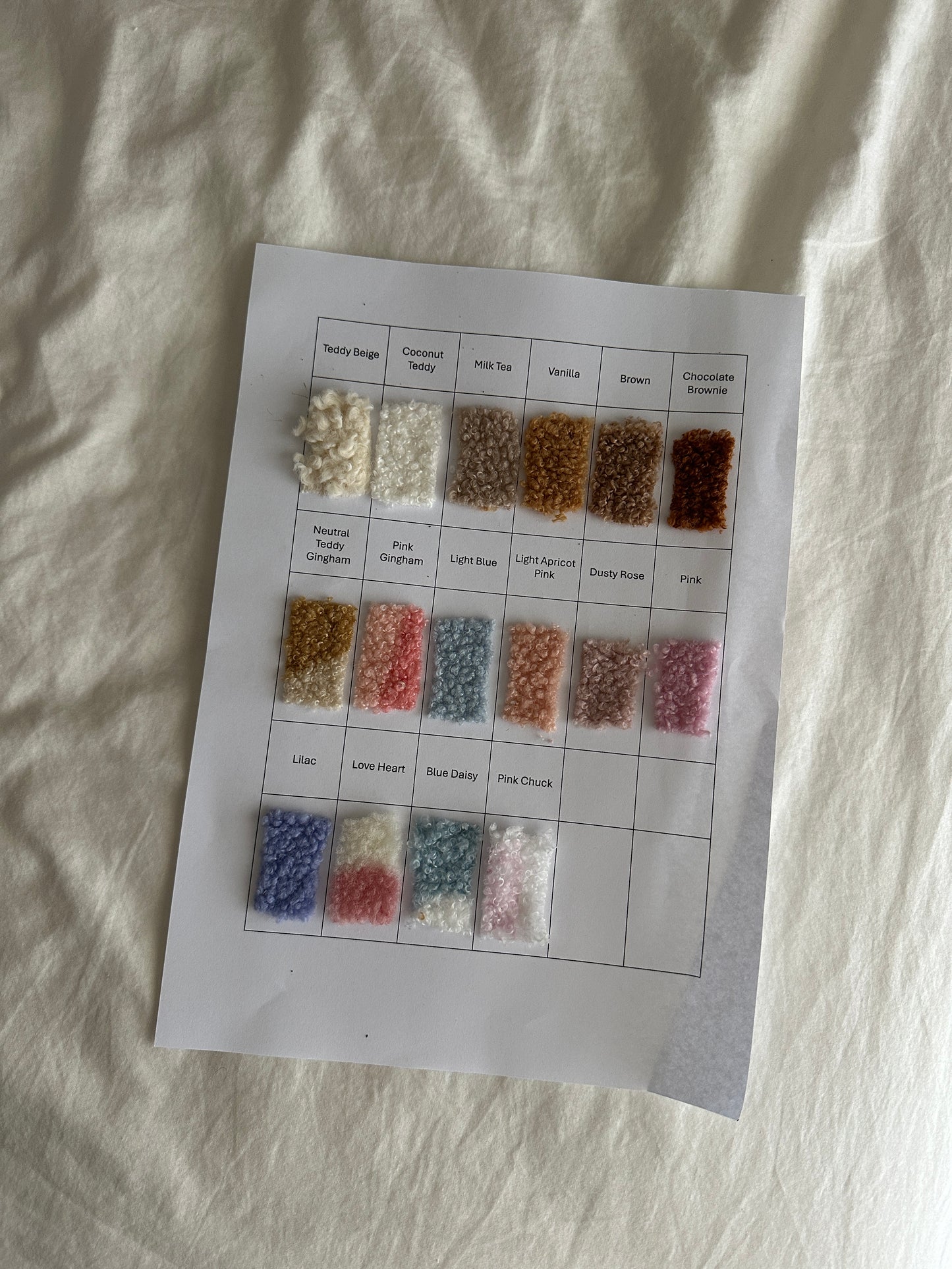 Color swatch chart with small samples of fabric colors on a white sheet