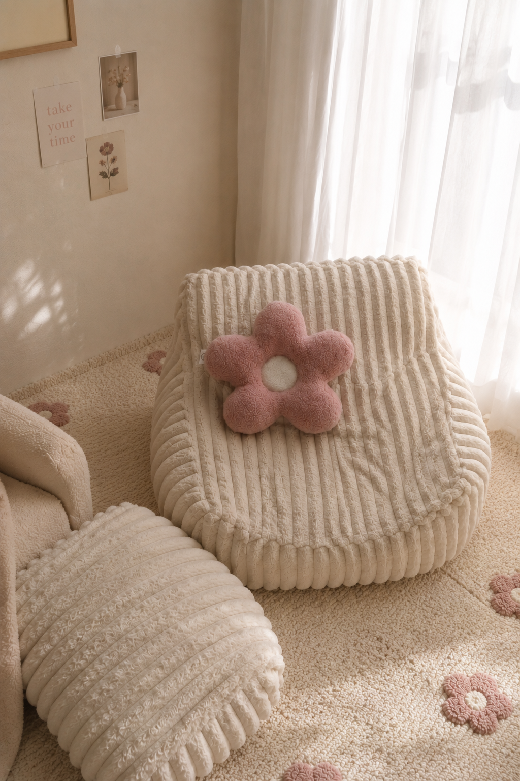 Fluffy beige chair with a pink flower-shaped pillow in a cozy room.